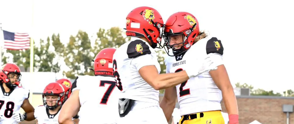 two ferris state football players celebrate on the field