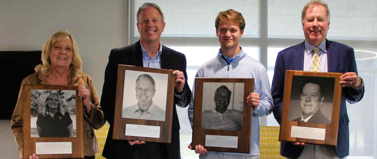four people holding up plaques