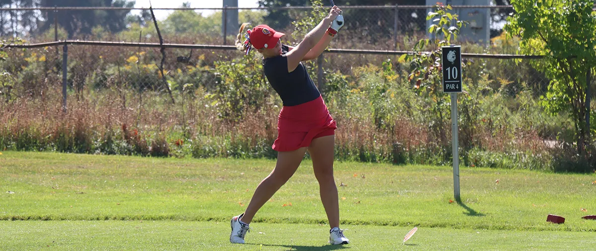 female golfer hits a ball on a golf course