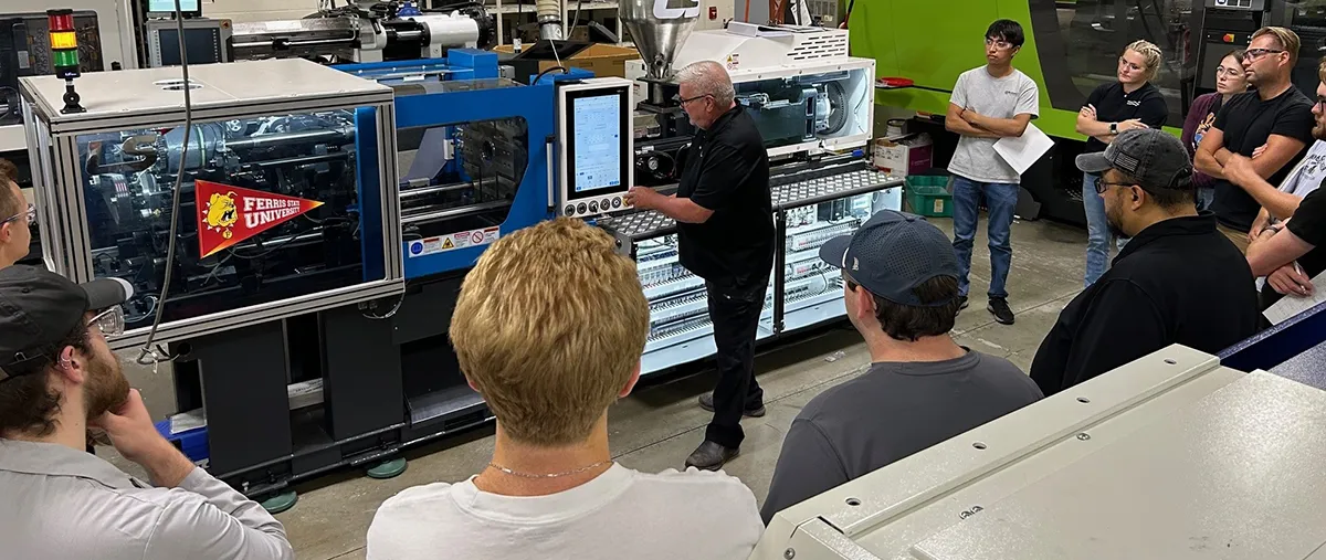 students standing around an injection molding machine