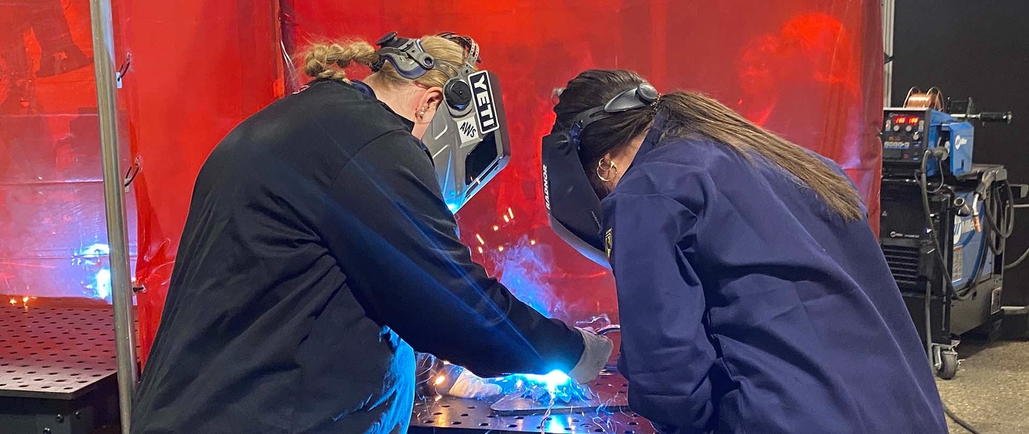 A pair of students welding during an in-class lab