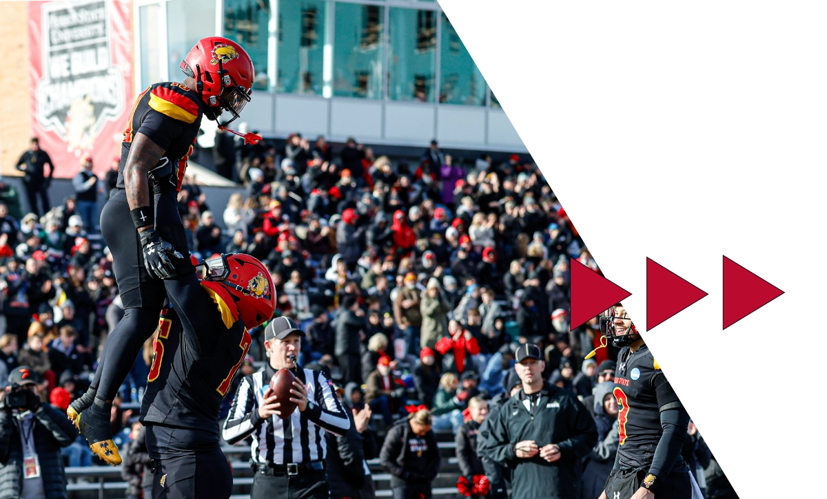 Ferris State football players lifts another player into the air in celebration after scoring a touchdown