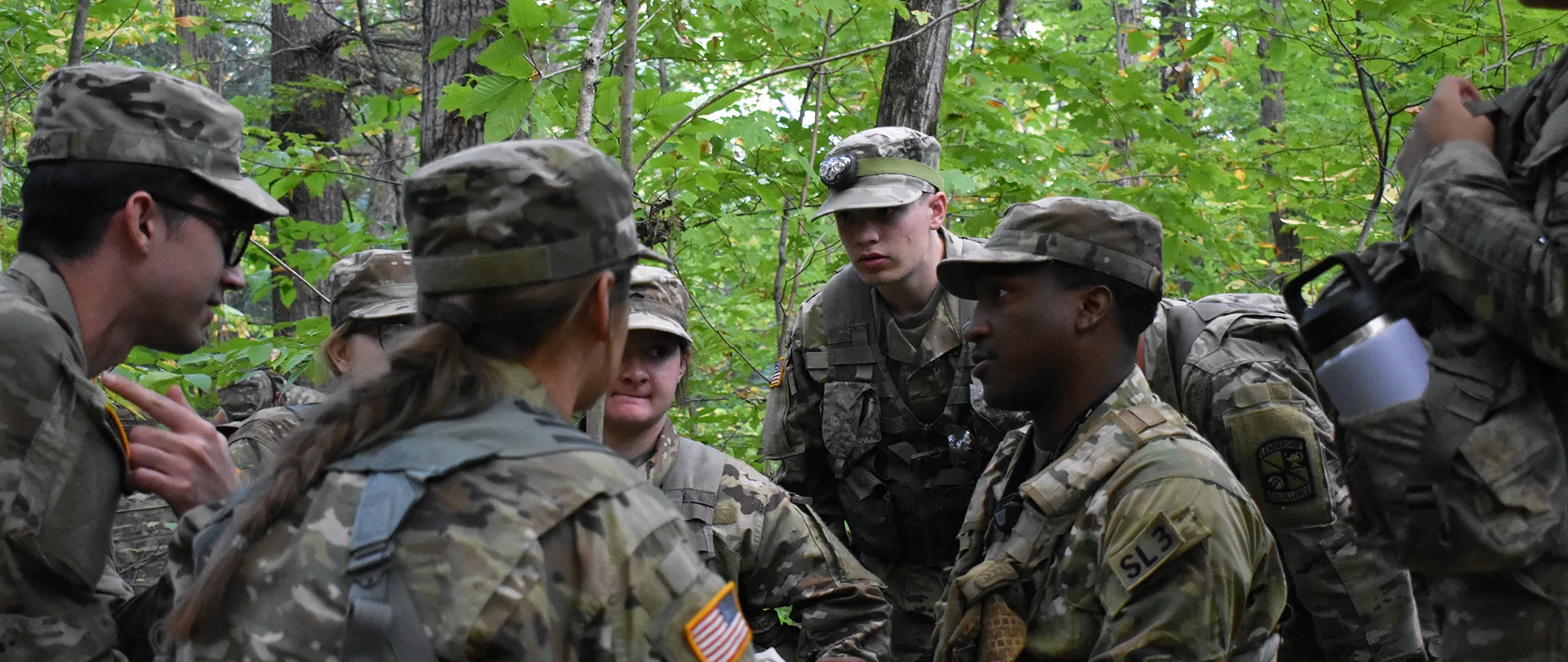 ROTC cadets in uniform in a forest environment