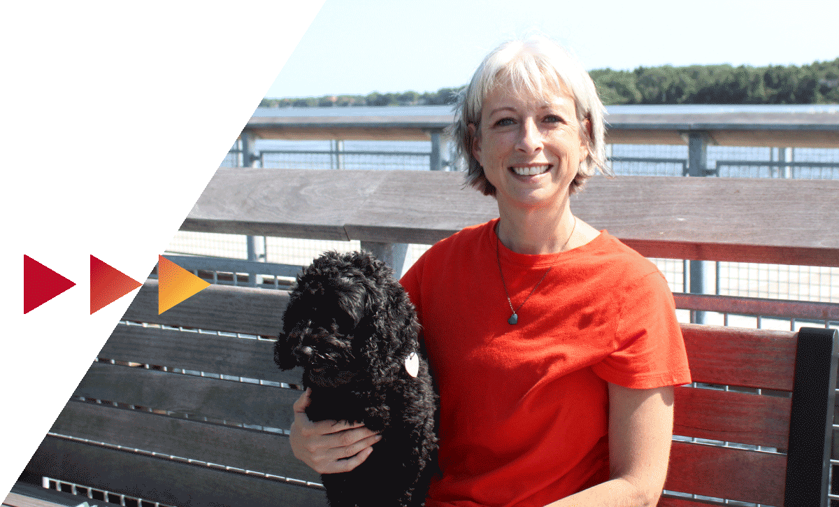 Student smiling with her dog.